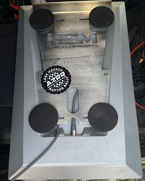 HSM mounting bracket with 'HSM' and 'Lake Havasu Raptor' logos on a blurred background. tester that was proven with 1000 offroad miles
