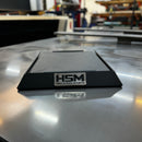 A black Starlink dish mount branded with 'HSM', placed on a metal surface, with the logo 'High Speed Mounts' visible.